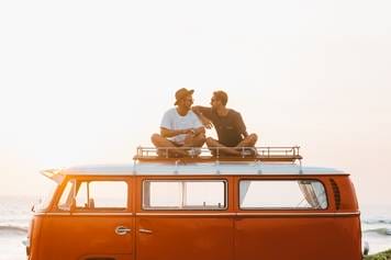 House of Hearing Richfield Utah - Two people sitting on top of a vw bus at sunset.