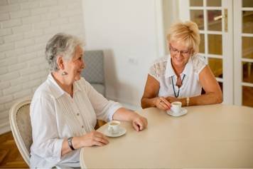 House of Hearing Richfield Utah - Two women talking at a table in a coffee shop.